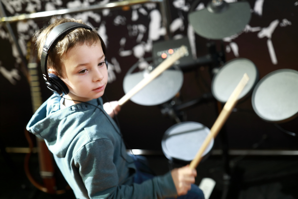 Kind lernt e Drums zu spielen